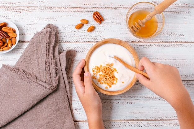 Close up shot of a woman's hands mixing honey, oats, and milk in a bowl to create a natural face mask.