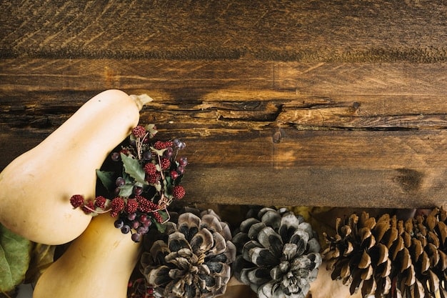 A well-lit dining table decorated for Christmas with a DIY centerpiece featuring a wooden crate filled with pinecones, candles, and greenery. The setting includes handmade placemats and napkin rings.