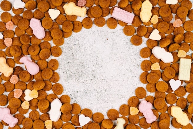 A variety of colorful, healthy homemade dog treats neatly arranged on a baking sheet, with ingredients like peanut butter and carrots visible.