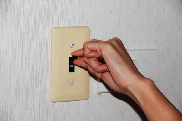 A close-up of a person unscrewing a light switch plate, with a non-contact voltage tester held nearby, emphasizing electrical safety.