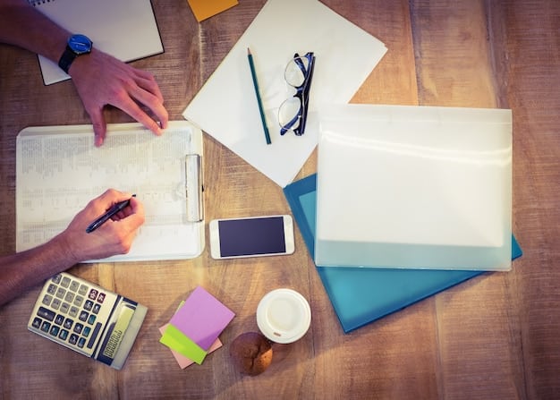 A person creating a budget plan with a laptop, notebook, and various bills on a well-organized desk, symbolizing financial planning.